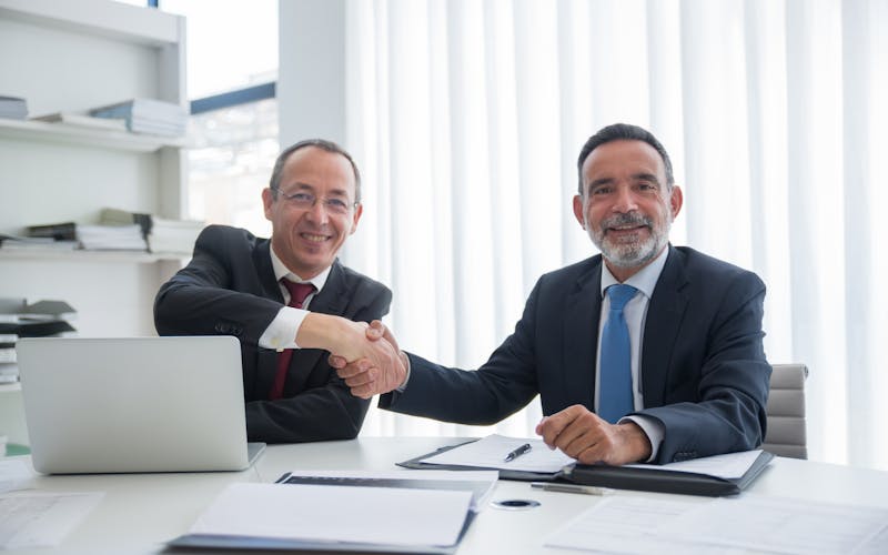 Poignée de main entre deux professionnels en costume